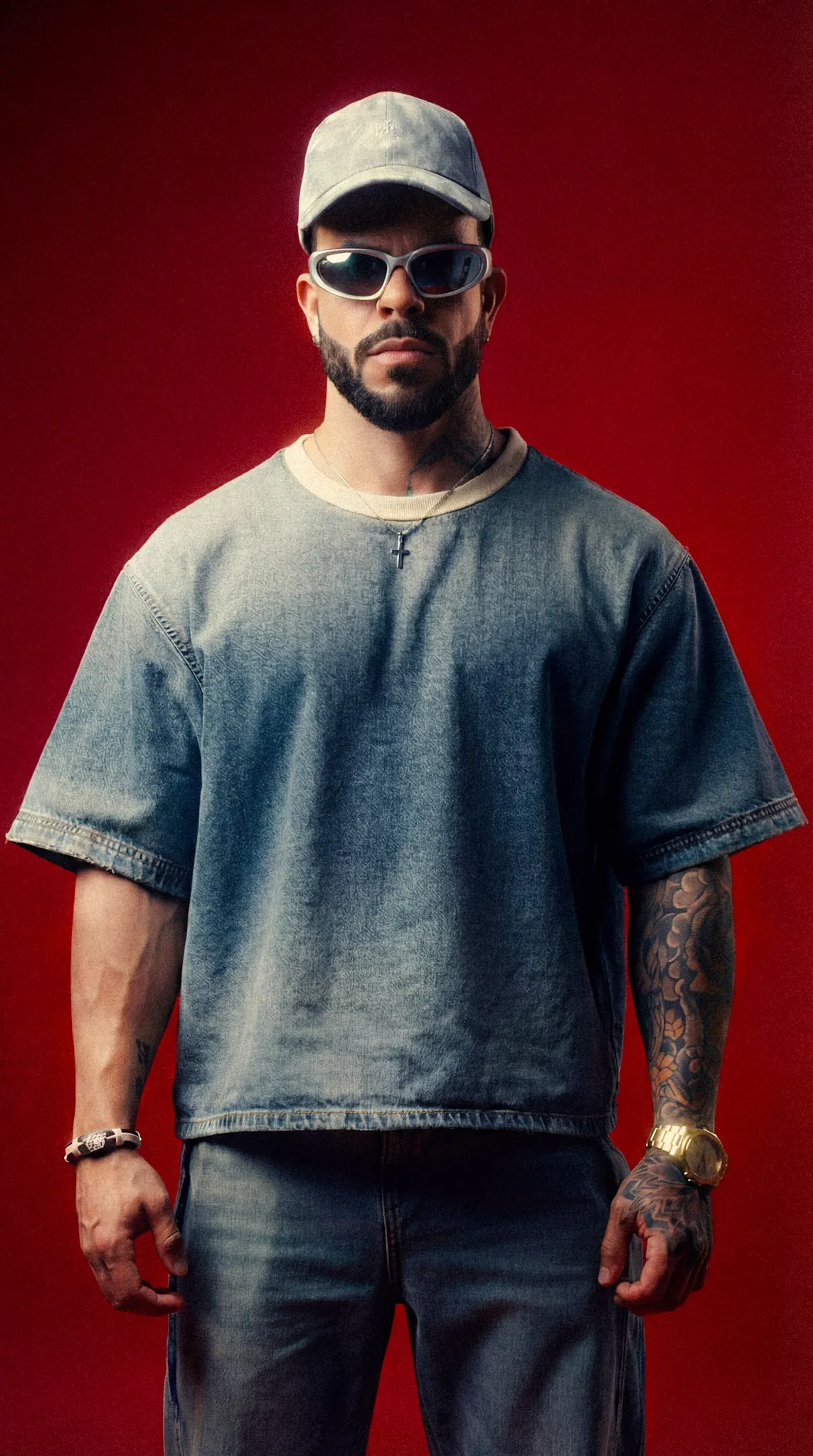 HIDEKI con conjunto denim y gorra sobre fondo rojo