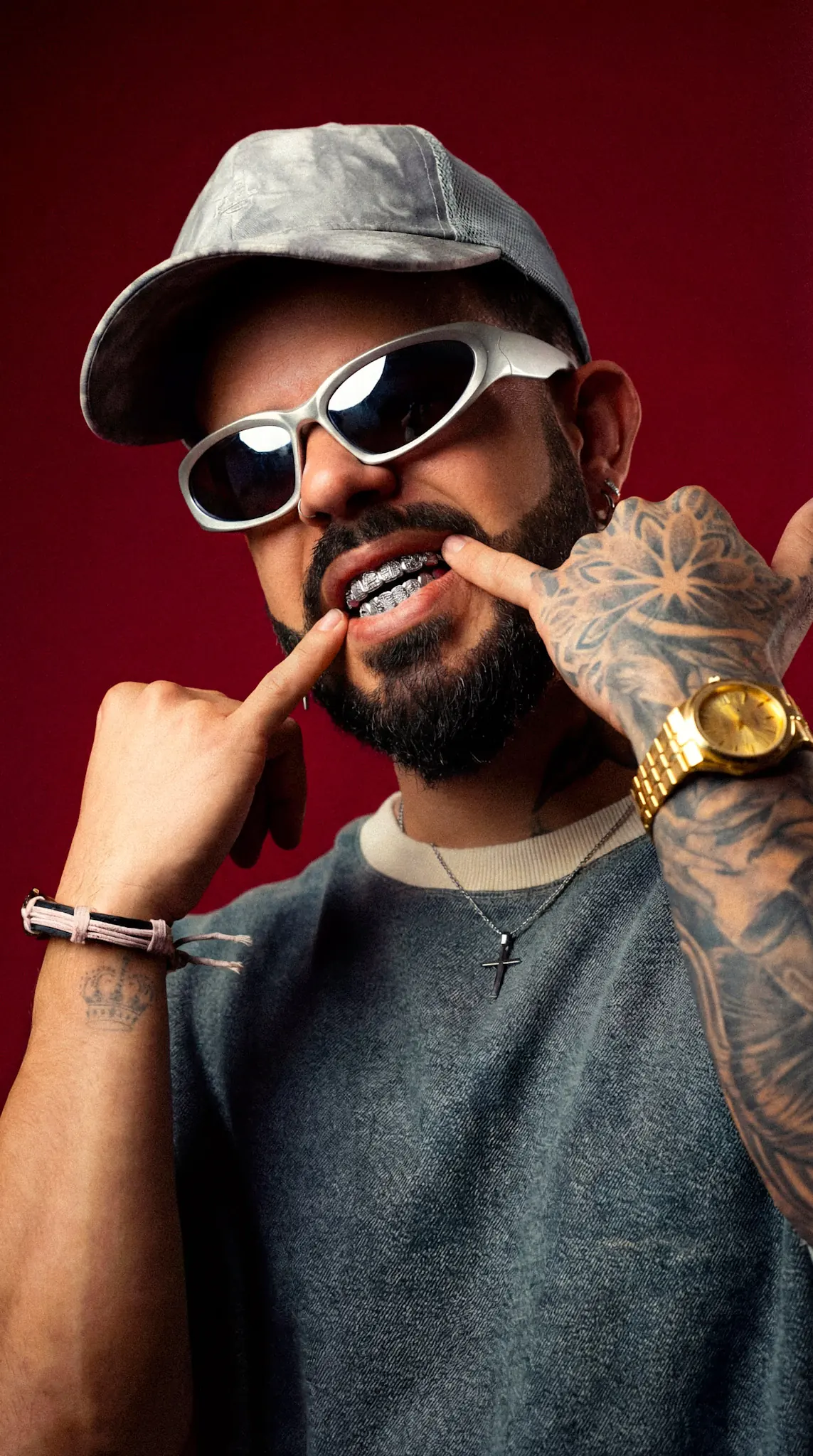HIDEKI con gorra y gafas blancas enseñando los grillz