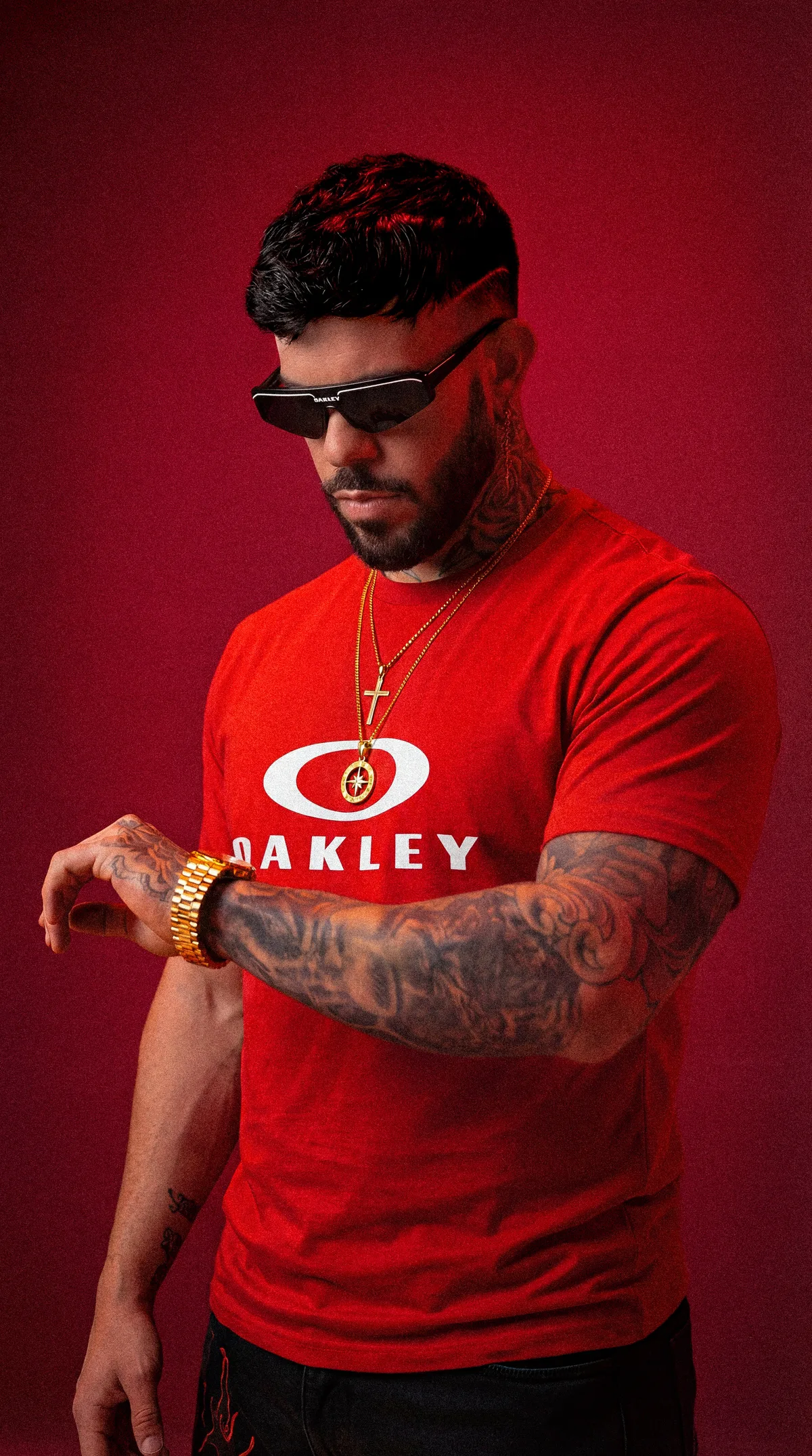 HIDEKI con camiseta roja Oakley ajustándose el reloj